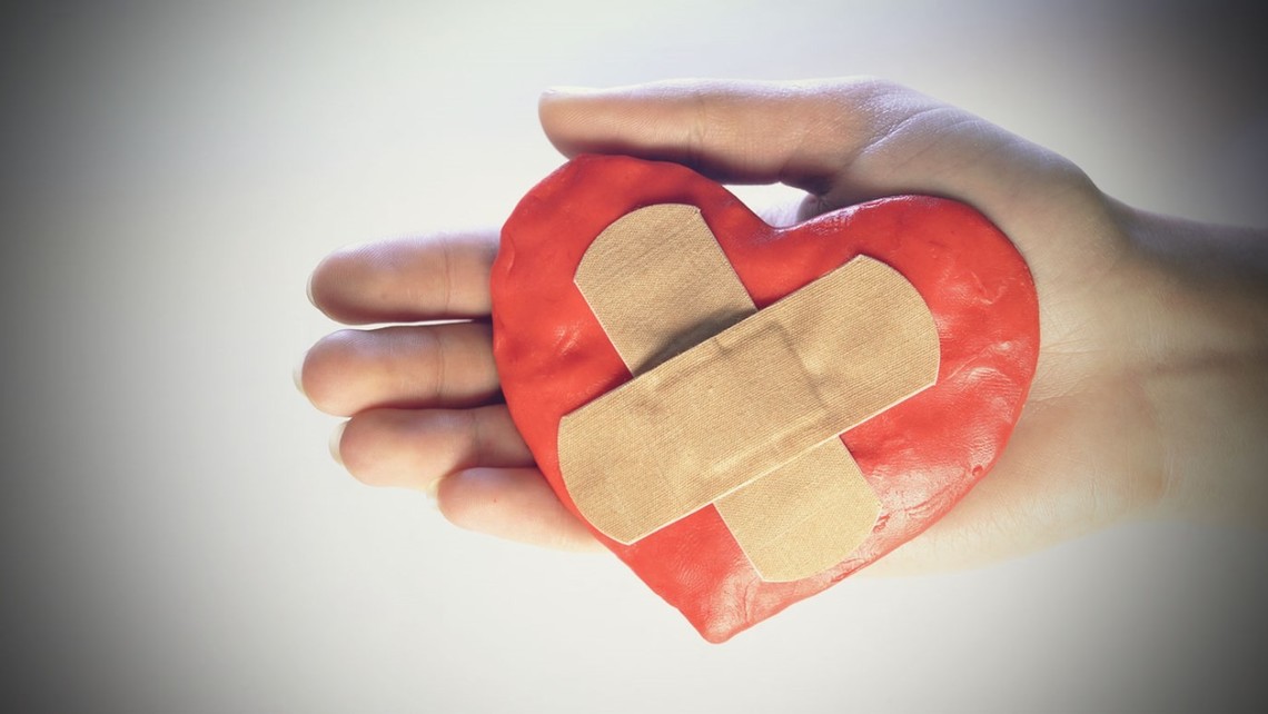 bandaged heart in hands